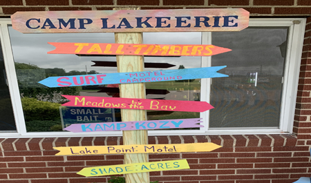a sign pointing towards all of the Camp Lake Erie properties